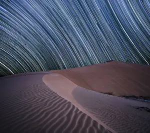 Starry Sky Prints: Equatorial star trail above sand dunes in the Rub al Khali desert, Oman, Middle East
