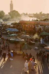 Market Square Prints: Evening light on the busy square of Place Jemaa el-Fna with the minaret of the Koutoubia Mosque in the distance