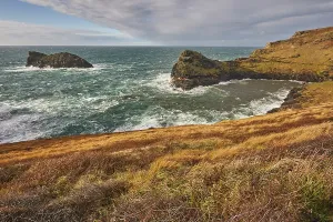 United Prints: Evening sunlight shines on cliffs at the entrance to Boscastle harbour along the Atlantic coast of Cornwall