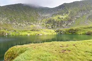 Romania Prints: Exploration of Capra Lake surrounded by Fagaras Mountains in Romania on a cloudy day