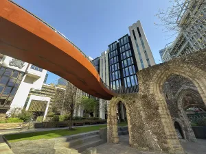Steel Prints: Exploration of modern architecture alongside historical ruins in London England on a clear day