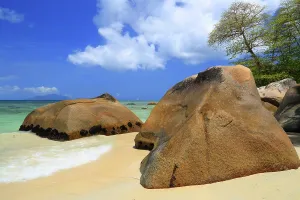 Tropics Prints: Explore Beau Vallon Beach in Mahe Seychelles with clear waters and large rocks along the sandy shore