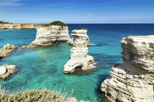 Getaway Prints: Explore faraglioni di Sant Andrea with clear blue waters and rocky formations in Salento Italy