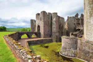 Monmouthshire Prints: Explore Raglan Castle with its ancient stone walls and historic architecture surrounded by green landscape in Wales