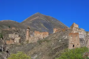 Settlement Prints: Exploring an abandoned mountain village in Chechnya with ruins and a distant mountain in the sky