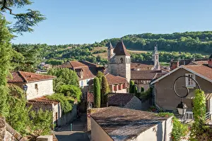 Cobblestone Prints: Exploring Figeac with its historic architecture and surrounding hills under clear blue skies
