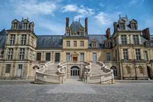 Cobblestone Prints: Exploring Fontainebleau palace with its grand architecture and detailed staircases on a clear day in France