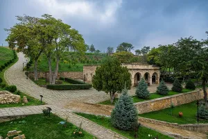 Traditions Prints: Exploring Naryn-Kala Fortress with stone pathways and green trees in Derbent