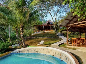 Enjoyment Prints: Exploring outdoor spaces at a hostal with a pool and nearby dining area in Lanquin