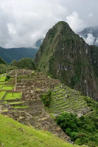 Terraces Prints: Exploring the ruins of an ancient Inca city on a mountain in Peru with green terraces and cloudy skies
