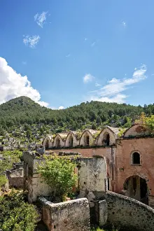 Ghost Prints: Exploring the ruins of Kayakoy Greek ghost town with mountains and vegetation in the background in Fethiye Turkey