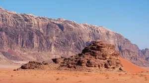 Dunes Prints: Exploring Wadi Rum desert terrain with rocky formations and bright blue sky in Jordan