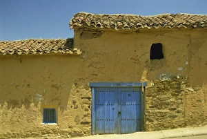 Old Castile Prints: Exterior of an adobe house with a tile roof and blue door