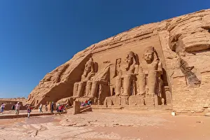 Nubia Prints: Exterior view of tourists and massive sculptures at the Abu Simbel Temple next to Lake Nasser