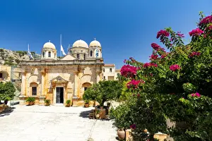 Patriotism Prints: Facade of the old monastery of Agia Triada of Tzagarolon surrounded by bougainvillea in summer