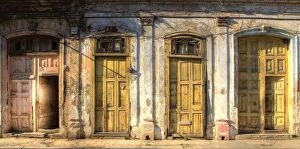 Facades of dilapidated colonial buildings bathed in evening light, Havana