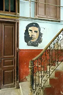 Patriotism Prints: Faded mural of Che Guevara on the staircase of a dilapidated apartment building