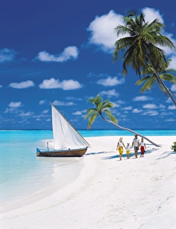 Enjoying Prints: Family walking on a tropical beach by traditional dhoni, Maldives, Indian Ocean, Asia