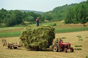 Couple Prints: Farming couple with tractor and full trailer during haymaking in a field near Lalbenque