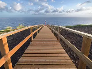 Farolim dos Fenais da Ajuda lighthouse with a symmetrical wooden path leading to it, Sao Miguel island, Azores Islands, Portugal, Atlantic, Europe