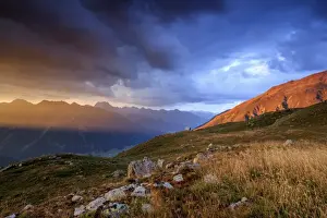 Muottas Muragl Prints: Fiery sky and dark clouds on high peaks of Muottas Muragl at sunset, St