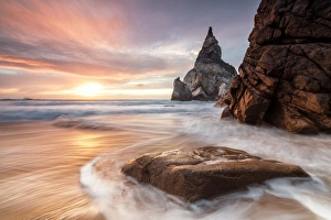 Sintra Prints: The fiery sky at sunset is reflected on the ocean waves and cliffs, Praia da Ursa