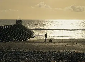 Fisherman Prints: Fisherman on the beach silhouetted against the winter sun where the Arun estuary enters the sea