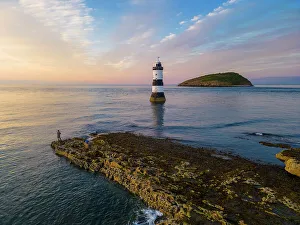Lighthouses Prints: Fisherman at Trwyn Du Lighthouse at sunset in summer