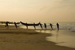 Fishing Net Prints: Fishermen hauling in nets at sunrise, Chowara Beach, near Kovalam, Kerala, India, Asia