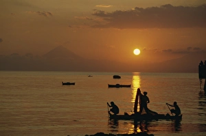Fishermen silhouetted at sunset at Ende on the island of Flores