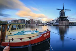The Netherlands Prints: The fishing boat frames the Windmill De Adriaan reflected in the River Spaarne at dusk