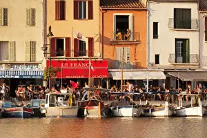 Provence Alpes Cote Dazur Prints: Fishing boats at the harbour, restaurants and street cafes on the promenade, Cassis