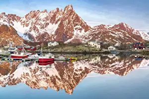 Fishing boats and snowcapped mountains mirrored in the fjord at sunrise, Ballstad, Vestvagoy, Lofoten Islands, Norway, Scandinavia, Europe