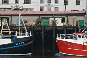 Whitby Prints: Fishing boats in Whitby harbour with the famous Magpie Cafe in the background