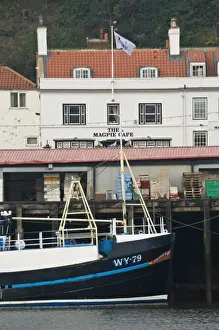 Fishing boats in Whitby harbour with the famous Magpie Cafe in the background