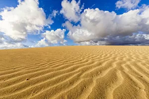 Rippled Gallery: Fluffy clouds over desert sand dunes modeled by wind, Corralejo Natural Park, Fuerteventura