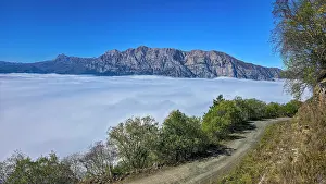 Fresh Prints: Fog covers valley with mountains in view near a dirt road in North Ossetia, Russia