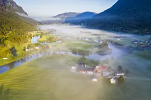 Fog over farms and fields along Stryneelva river, aerial view, Stryn, Nordfjorden