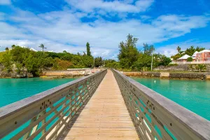 Trail Prints: Footbridge over water leads to lush greenery and homes in Bermuda near the Railway Trail
