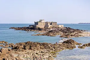 Saint Prints: Fort National stands on rocky islet with people exploring nearby coast in Saint Malo area of Brittany France