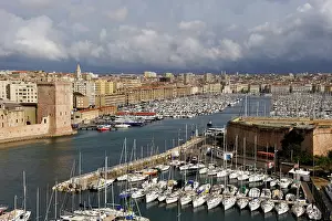 Navigation Prints: Fort Saint-Jean stands at the entrance of the Old Port in Marseille with boats lined up in the harbor under a cloudy