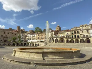 Lively Prints: Fountain in the center of Plaza Major with buildings and blue sky in Trujillo