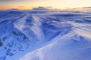 Arctic Gallery: Fresh snow shaped by the cold Arctic wind blowing over mountains at dawn, Tana