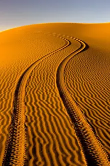 Dunes Prints: Fresh tyre tracks left by 4x4 recreational vehicle in the pristine sands of the Erg Chebbi sand sea near Merzouga