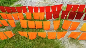 Hanging Prints: Freshly dyed cloths hang to dry under the sunlight in a village setting