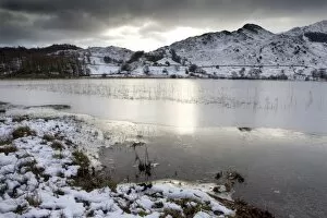 Frozen Little Langdale Tarn and snow-covered fells, near Ambleside, Lake District National Park
