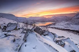 Troms County Prints: Frozen sea surrounded by snow framed by the orange sky at sunset, Torsken, Senja