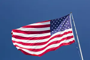 Old Towns Prints: Giant US flag flying beneath a deep blue sky above Truman Avenue, Old Town, Key West