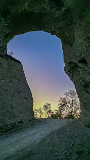 Geological Prints: Giant rock arch stands in the Chechen mountains against a sunset sky in the Caucasus region of Russia