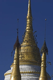 Keng Tung Prints: Gilded zedi, said to contain Buddhas hair relics, topped by gold hti inlaid with silver